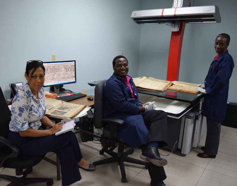 Dr Kwynn Johnson, Curator of the 125-year Catholic News Digital Archive, along with Mr Malachi Alexis and Ms Deborah Best of the National Archives at the National Archives’ Reprographics Lab. Photo by Mark Lyndersay. 